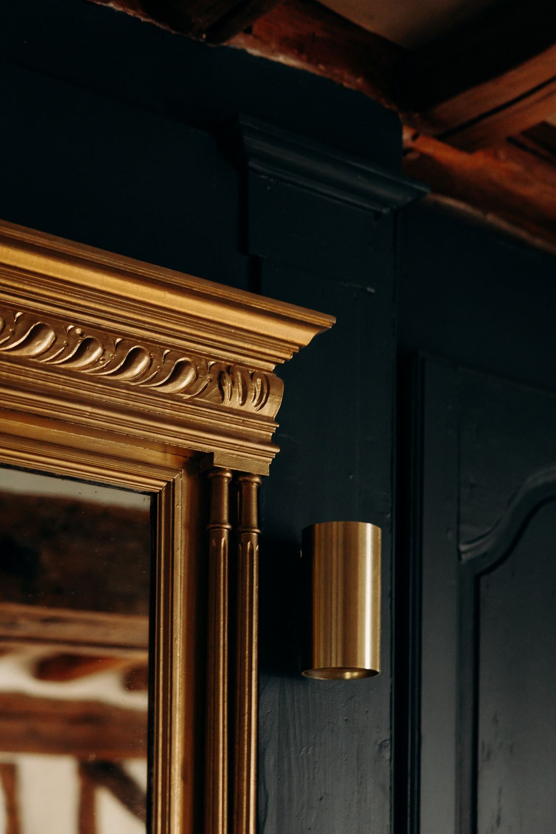 Miroir doré sur les boiseries bleu nuit